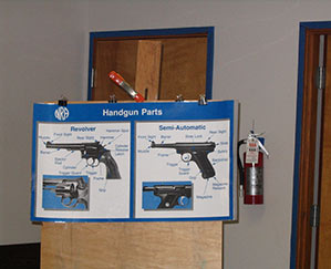 NRA training poster shows parts of a hand gun and pistol