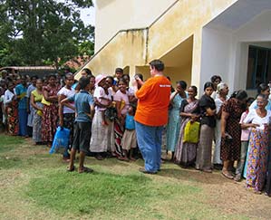 A World Vision volunteer takes pictures of people lining up for supplies in Sri Lanka following the 2004 tsunami
